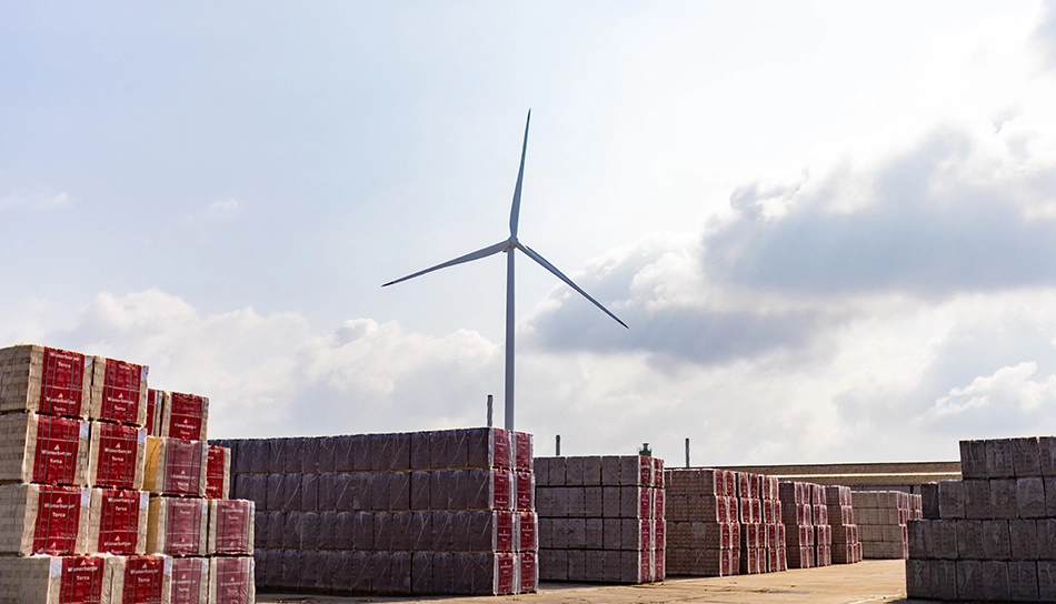 Blick vom Boden auf ein Windrad und Ziegelpakete im wienerberger Ziegelwerk (Foto)