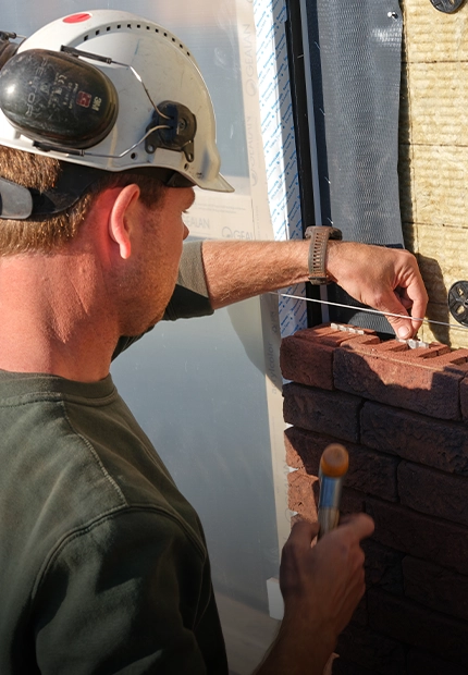 Mann verlegt Ziegel bei der Renovierung und Erweiterung der historischen Orangerie in Baarn, Niederlande mit dem wienerberger ClickBrick-System (Foto)